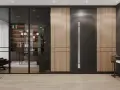 Nowoczesne drzwi wewnętrzne loft z przeszkleniem, otoczone panelami drewnianymi, tworzą stylowe przejście do gabinetu.