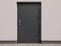 Solidne drzwi techniczne antracyt z metalowym uchwytem, osadzone w jasnej, chropowatej ścianie.