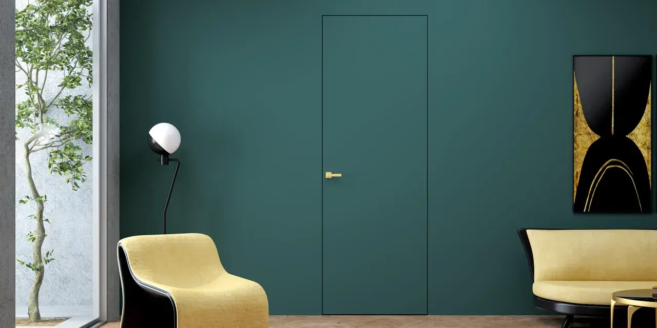 Nowoczesne drzwi wewnętrzne z ukrytymi zawiasami, idealnie wtapiające się w ścianę. Złota klamka dodaje elegancji.