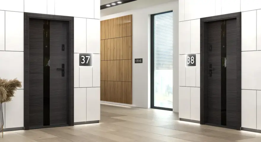Eleganckie drzwi wewnątrzklatkowe akustyczne w ciemnym drewnie, z numerami mieszkań 37 i 38.