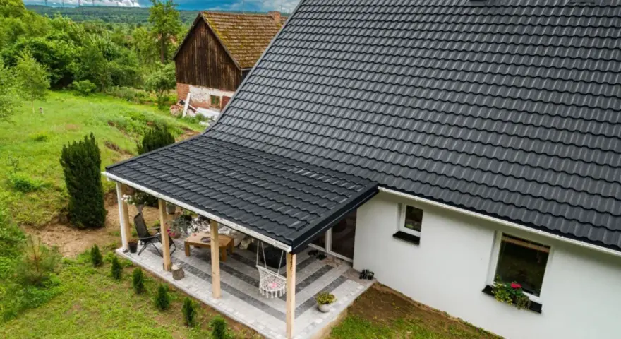Nowy, ciemny dach z dachówki nad tarasem. Dowiedz się, jak naprawić dach z dachówki, by służył latami.