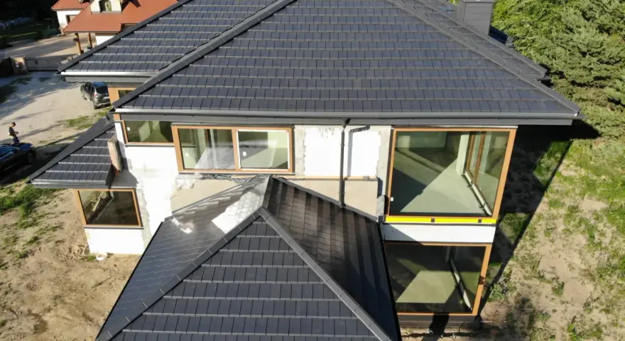 Nowy, ciemny dach z dachówki ceramicznej. Zastanawiasz się, ile kosztuje wymiana pokrycia dachowego?